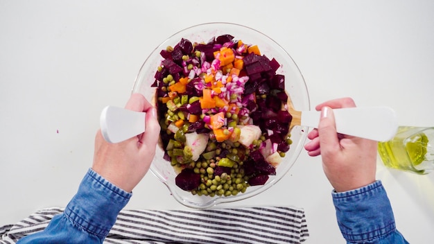 Hands preparing a colorful salad